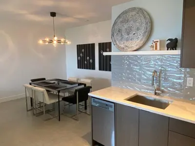 a kitchen with a sink and a table with chairs at Winchelsea Views in Nanaimo