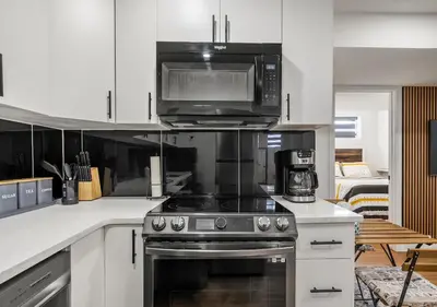 a kitchen with a stove and a microwave at Mountain Hideaway Two Bedrooms Free Park Pass in Cochrane