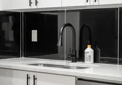 a kitchen counter with a sink and two faucets at Mountain Hideaway Two Bedrooms Free Park Pass in Cochrane