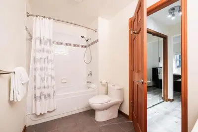 a bathroom with a toilet and a tub and a shower at Deer Run by Outpost Whistler in Whistler