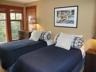 a bedroom with two beds and a window at Whistler Ski In Ski Out in Whistler