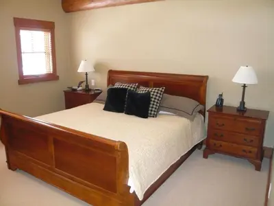a bedroom with a wooden bed with two night stands and two lamps at Whistler Ski In Ski Out in Whistler