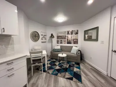 a living room with a couch and a table at Serenity 1BR & 1 DEN Home at Folsom Ave in Coquitlam