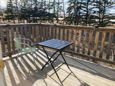 a table and a chair sitting on a deck at Tudor House Bed and Breakfast in Bottrel