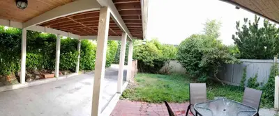 a patio with a table and chairs in a backyard at Bright 2 BR, Great Location in West Vancouver