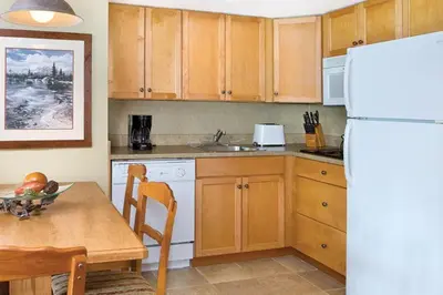 a kitchen with a table and a white refrigerator at Worldmark Canmore Banff Alberta Canada in Canmore