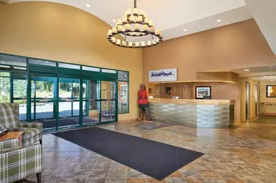 a lobby of a hotel with a woman standing at a counter at Worldmark Canmore Banff Alberta Canada in Canmore