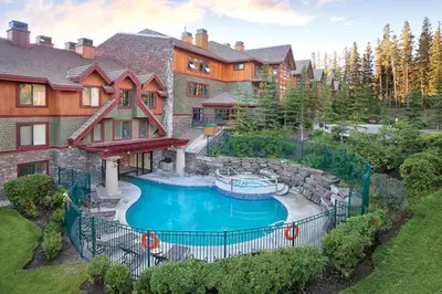 an estate with a swimming pool in front of a house at 2 Bd Worldmark Canmore Banff Condo in Canmore