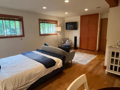 a bedroom with a large bed and a chair at A Seaside Jacuzzi Escape in Parksville, BC, Canada in Parksville