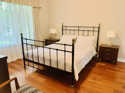 a bedroom with a black bed and two night stands at Richmond Garden Retreat in Richmond