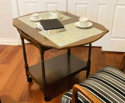 a small wooden table with a book and plates on it at Richmond Garden Retreat in Richmond