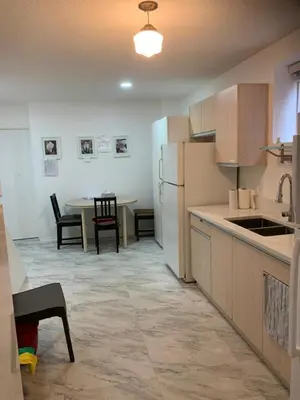 a kitchen with a table and a white refrigerator at Exclusive Offer - A special deal ending soon!! Super Nice Location - Very close to YVR Airport and shopping center & easy transportation in Vancouver