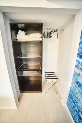 a walk in closet with a refrigerator and a chair at Upscale Modern Apartment in Whistler