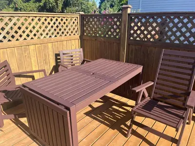 a wooden picnic table and two chairs on a deck at Serenity Bed and Breakfast in Comox