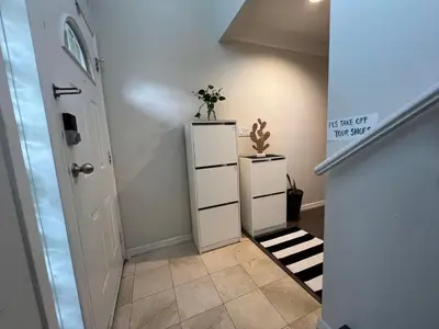 a hallway with a white cabinet with a plant on it at Vancouver airport 7mins away joy room in Richmond
