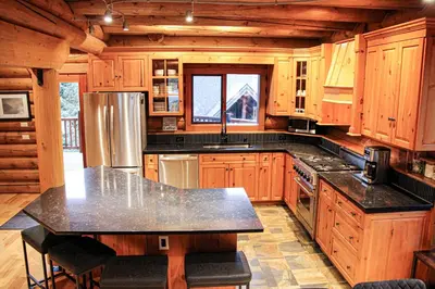 a large kitchen with wooden cabinets and a counter top at GrizzPaw Lodge - Mountain Resort - 5 Bedroom Chalet - Sleeps 14 People in Golden