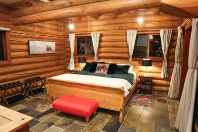 a bedroom with a bed in a log cabin at GrizzPaw Lodge - Mountain Resort - 5 Bedroom Chalet - Sleeps 14 People in Golden