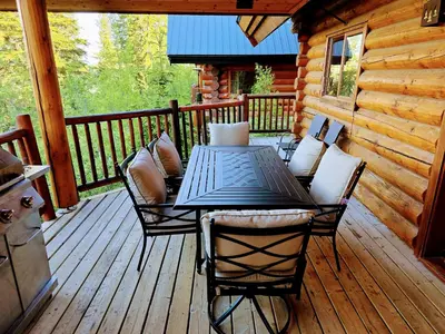 a wooden deck with a table and chairs on a cabin at GrizzPaw Lodge - Mountain Resort - 5 Bedroom Chalet - Sleeps 14 People in Golden