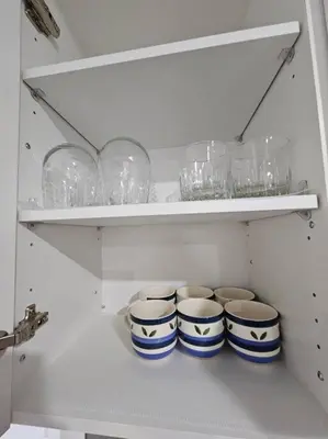 a white cabinet with blue and white bowls and glasses at Entire guest suite in Cochrane, AB in Cochrane