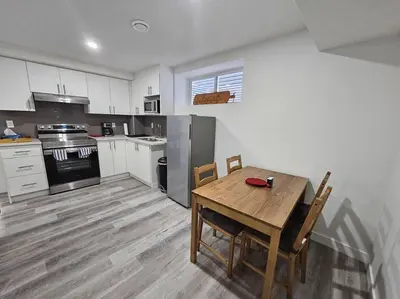 a kitchen with a wooden table and a table and chairs at Entire guest suite in Cochrane, AB in Cochrane