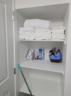 a white closet with towels and a rack of towels at Cozy New 1 bed basement suite in Edmonton