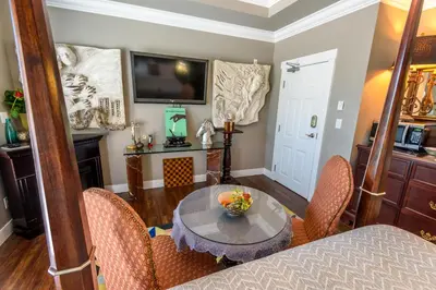 a dining room with a table and chairs and a television at Brookside Inn Boutique Hotel in Abbotsford