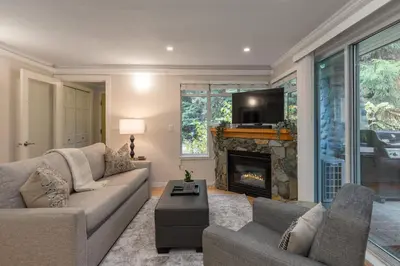 a living room with a couch and a fireplace at 1BR in Sunpath, Epic Village Location, Private Patio, Pool and Hot Tub, Parking in Whistler