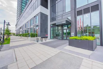 a building with a bench in front of it at New condo near Lougheed Mall & SFU in Coquitlam