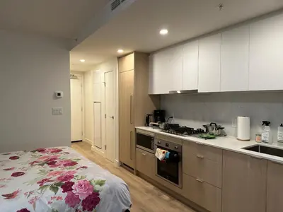a kitchen with white cabinets and a stove top oven at New condo near Lougheed Mall & SFU in Coquitlam