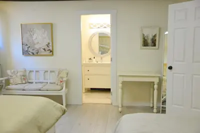 a bedroom with a bed and a sink and a mirror at Bright Spacious 3 BR Garden Suite, 4 Queen beds, Fully equipped, Highly recommended by 229 happy groups in Burnaby
