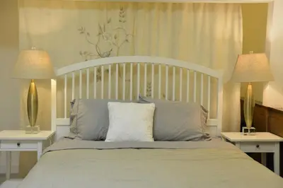 a bedroom with a white bed with two lamps at Bright Spacious 3 BR Garden Suite, 4 Queen beds, Fully equipped, Highly recommended by 229 happy groups in Burnaby