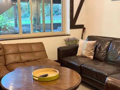 a living room with two leather couches and a table at Bright Spacious 3 BR Garden Suite, 4 Queen beds, Fully equipped, Highly recommended by 229 happy groups in Burnaby