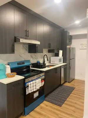 a kitchen with a stove and a counter top at Pebbles' Cozy 2Bed Basement Suite - near Downtown in Edmonton