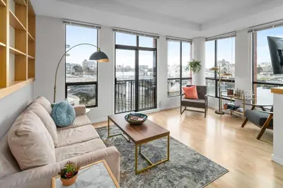 a living room with a couch and a table at Water Views From Every Window in Victoria