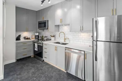 a kitchen with white cabinets and a stainless steel refrigerator at Water Views From Every Window in Victoria