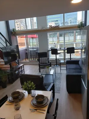a living room with a table and chairs and a piano at New York Style Loft in Downtown Vancouver-Ideal for World Cup 2026, Sleeps 4 in Vancouver