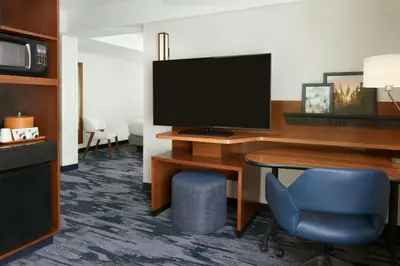 a hotel room with a desk with a television and a chair at Fairfield Inn & Suites by Marriott Calgary Downtown in Calgary
