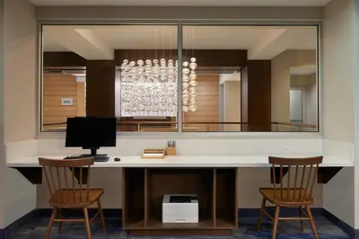 a room with a desk with two chairs and a mirror at Fairfield Inn & Suites by Marriott Calgary Downtown in Calgary
