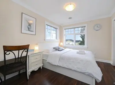 a bedroom with a bed and a desk and a chair at 7 Bedrooms in the Heart of Vancouver in Vancouver