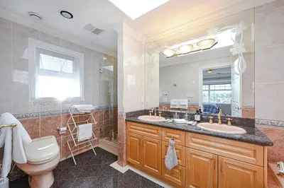 a bathroom with two sinks and a toilet and a mirror at 7 Bedrooms in the Heart of Vancouver in Vancouver