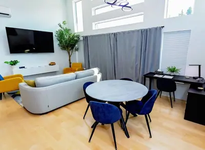 a living room with a couch and a table and chairs at LuxQuarters Huckleberry Suite in Kitimat