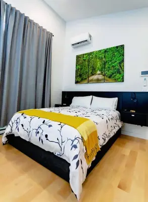 a bedroom with a bed with a yellow and white blanket at LuxQuarters Blueberry Studio in Kitimat
