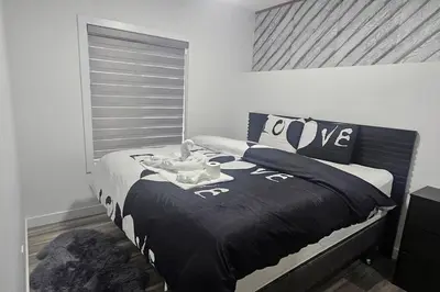a bedroom with a bed with a black and white comforter at Serenity&Luxury Redefined - A waterfront adventure in Airdrie