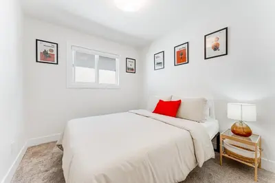 a white bedroom with a bed and a window at Riley Park-Modern 4 Bedroom Home, Central location in Vancouver