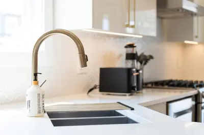 a kitchen sink with a bottle of soap next to it at Riley Park-Modern 4 Bedroom Home, Central location in Vancouver