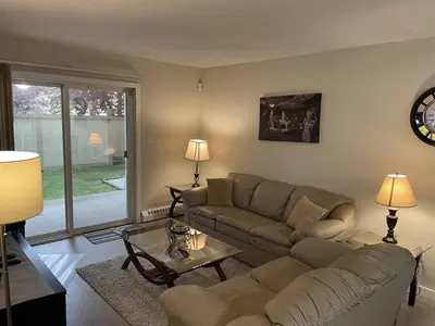 a living room with a couch and a table at Chris Cozy Condo Commonwealth #107 Edmonton in Edmonton