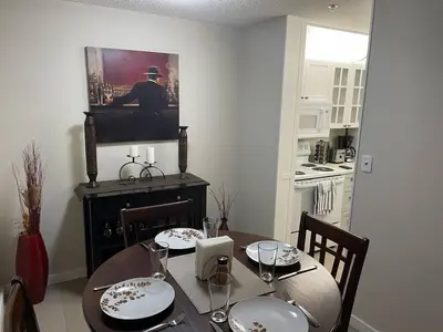 a dining room with a table and a tv on the wall at Chris Cozy Condo Commonwealth #107 Edmonton in Edmonton