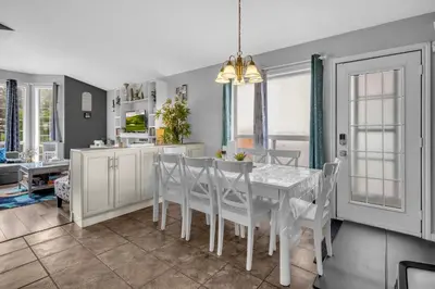 a kitchen and dining room with a white table and chairs at 33 Executive Home, Ac, Airport in Calgary