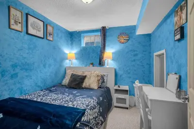 a blue bedroom with a bed and a sink at 33 Executive Home, Ac, Airport in Calgary