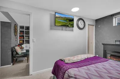 a bedroom with a bed and a tv on a wall at 33 Executive Home, Ac, Airport in Calgary